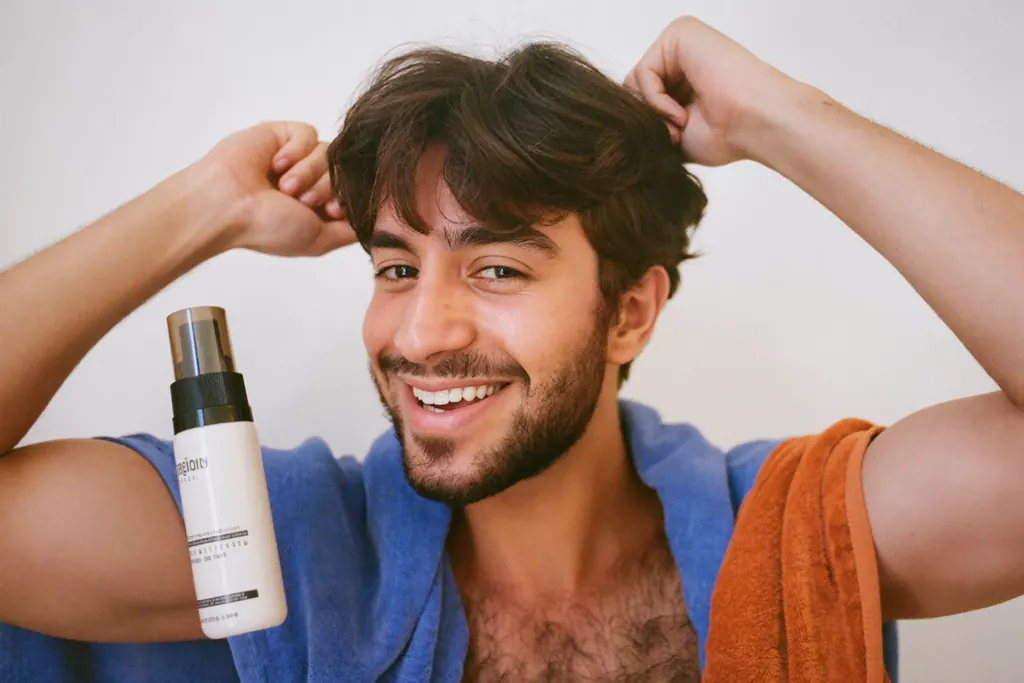 Hombre joven pasándose la mano por el cabello