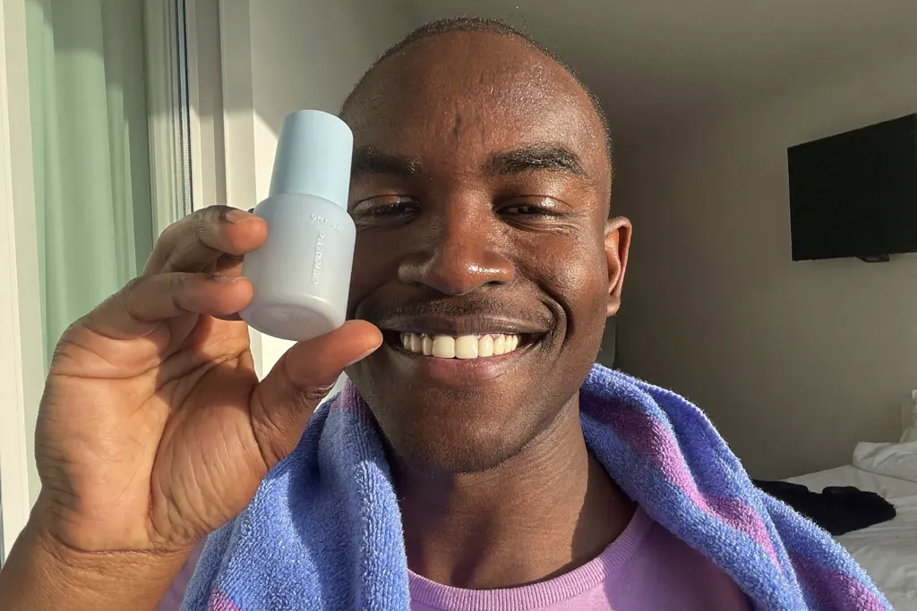 Hombre joven con la piel luminosa mirándose al espejo