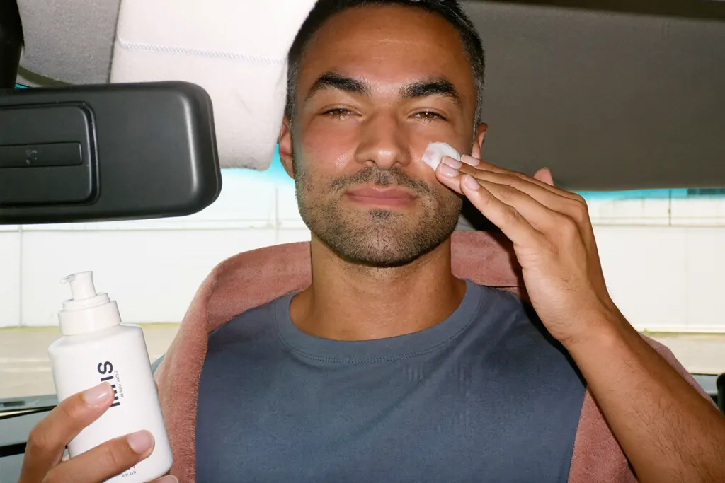 Hombre aplicándose crema facial