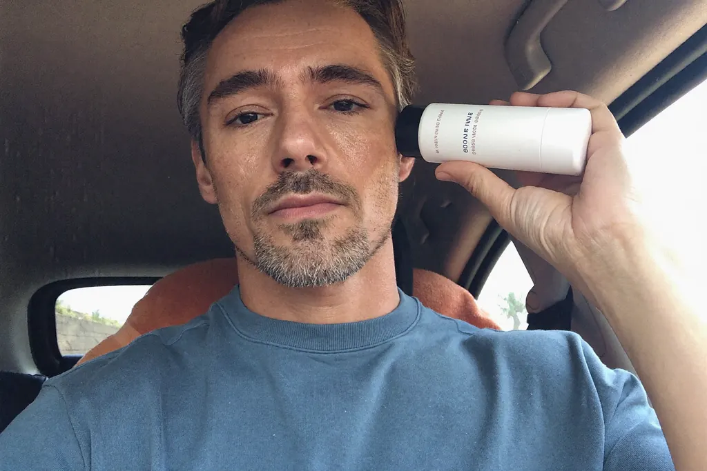 Hombre de cuarenta años aplicándose crema antiedad
